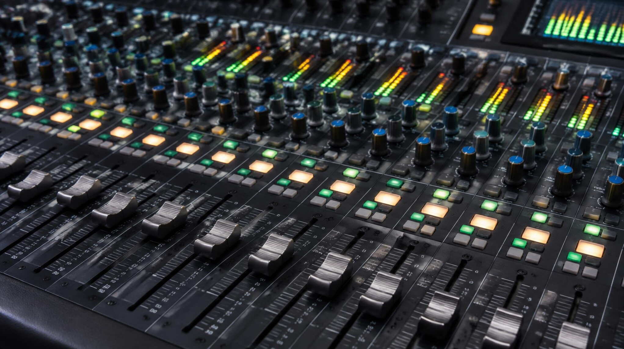 Audio mixing console with faders and meters